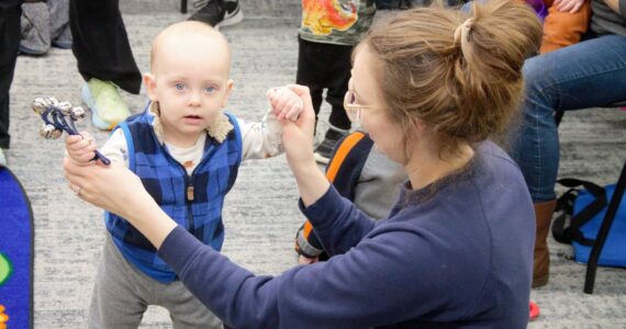 Elisha Meyer/Kitsap News Group Photos
A mom plays with her child, who is holding a bell instrument, during a morning Baby Band activity.