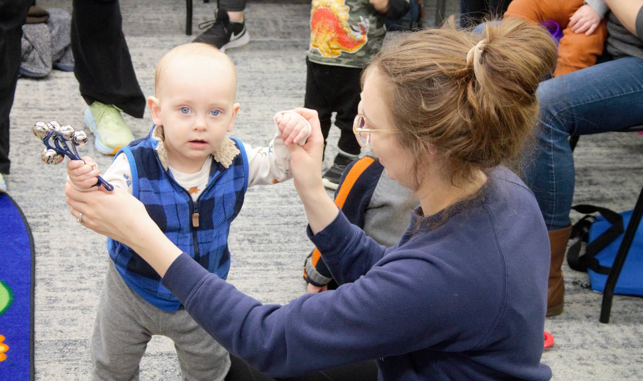 Elisha Meyer/Kitsap News Group Photos
A mom plays with her child, who is holding a bell instrument, during a morning Baby Band activity.