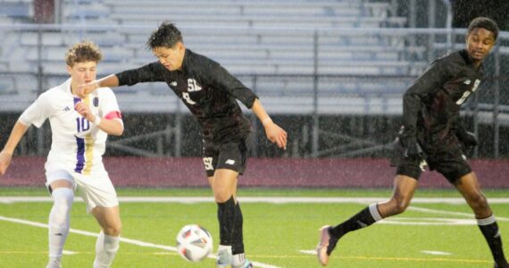 Rain persists as South Kitsap junior Gabriel Fernandez works to keep the ball moving through Sumner’s defense. Elisha Meyer/Kitsap News Group Photos