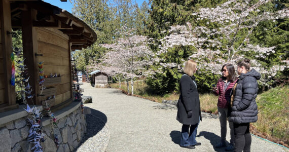 Chris Mueller, Ellen Sato Faust and Chantelle Lusebrink listen to the new audio tour, which features excerpts from recorded interviews of survivors sharing first-hand accounts of the exclusion. Nancy Treder/Kitsap News Group