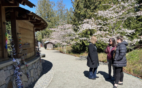 Chris Mueller, Ellen Sato Faust and Chantelle Lusebrink listen to the new audio tour, which features excerpts from recorded interviews of survivors sharing first-hand accounts of the exclusion. Nancy Treder/Kitsap News Group
