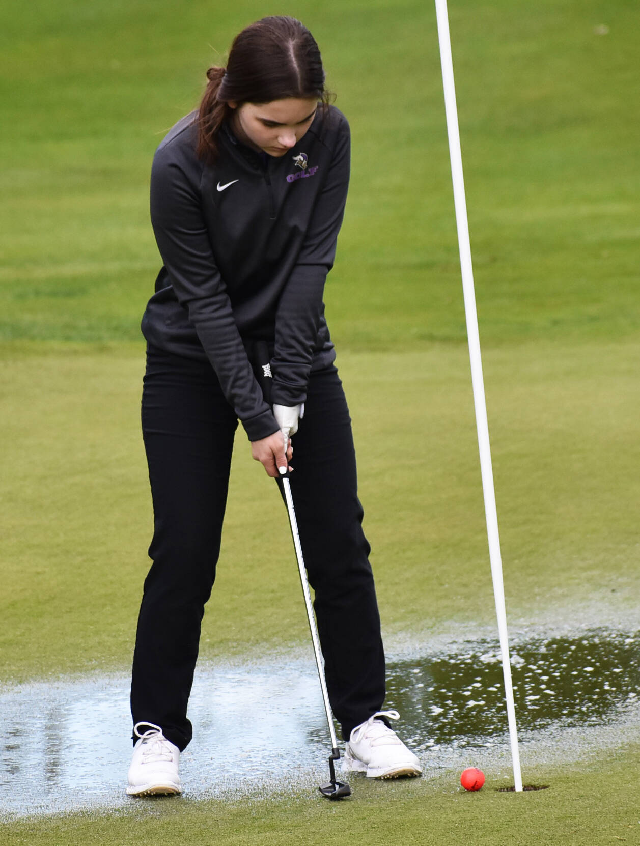 North Kitsap’s Calia Corden putts through a puddle to finished the second hole. Nicholas Zeller-Singh/Kitsap News Group Photos