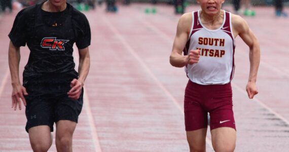 Sophomore Eon Hu (right) finishes strong in his heat of the 100-meter dash. Elisha Meyer/Kitsap News Group Photos