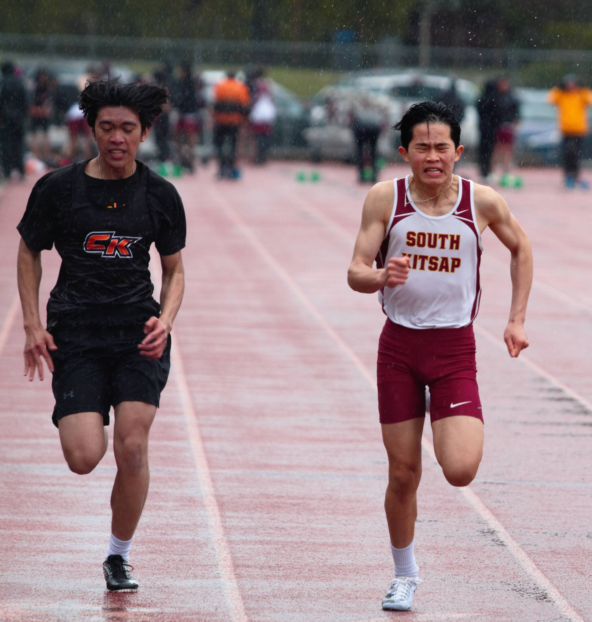 Sophomore Eon Hu (right) finishes strong in his heat of the 100-meter dash. Elisha Meyer/Kitsap News Group Photos