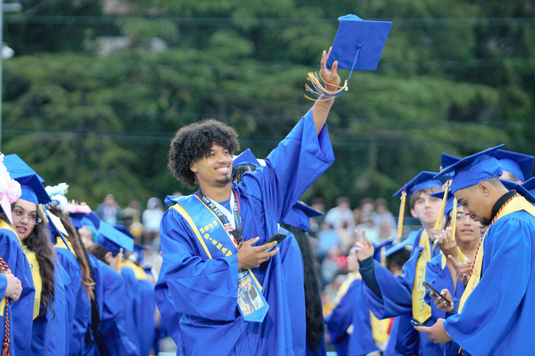A Bremerton graduate finds a familiar face in the crowd, doing so with a little help from his phone. Elisha Meyer/Kitsap News Group Photos