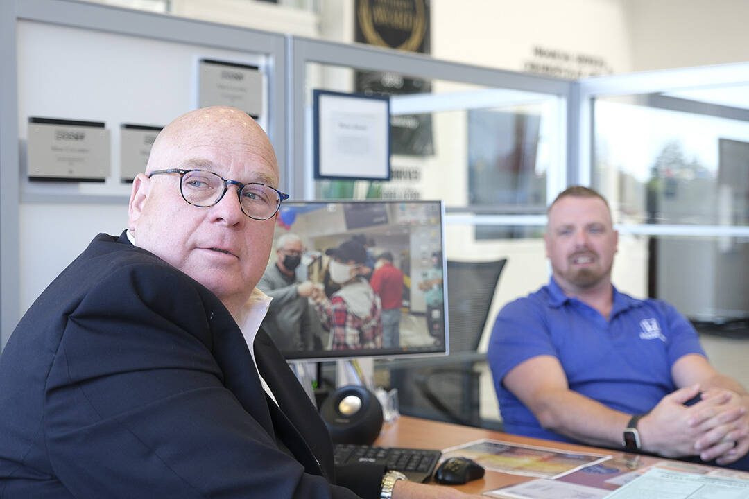 Mike Columbus, founder of Mike’s Ride for Lives, and Jeremy Clark, general sales manager, with an image of the first recipient of the charitable organization’s assistance on the computer screen. Damon Williams/Kitsap News Group