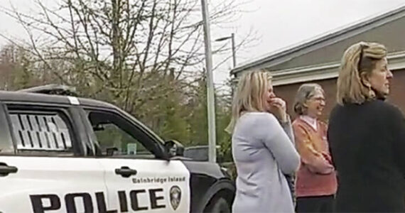 BI police courtesy photo
Adults try to get the boy to calm down in a Bainbridge Island police car in a church parking lot.