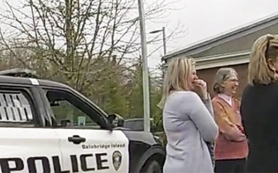 BI police courtesy photo
Adults try to get the boy to calm down in a Bainbridge Island police car in a church parking lot.