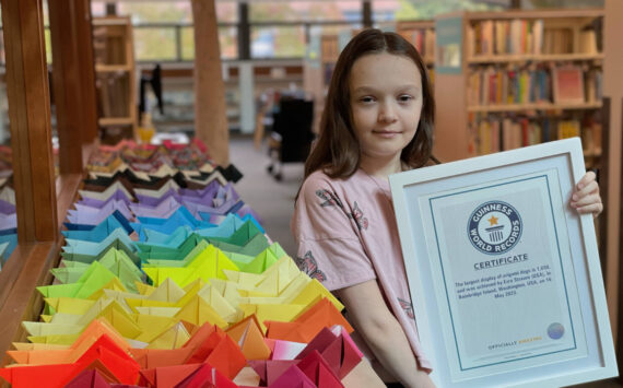Brynn Blanchard courtesy photo
Ezra Strawn, 12, poses with a certificate from Guinness World Records verifying her world record displaying 1,650 origami dogs May 16 at the Bainbridge Island Public Library.