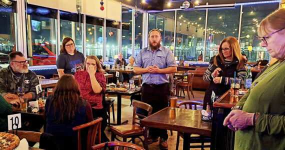 Elisha Meyer/Kitsap News Group
Gerry Austin, center, speaks with fellow South Kitsap School Supporters at Damn Fine Pizza minutes before results were announced.