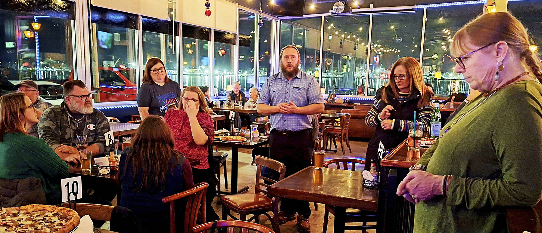 Elisha Meyer/Kitsap News Group
Gerry Austin, center, speaks with fellow South Kitsap School Supporters at Damn Fine Pizza minutes before results were announced.