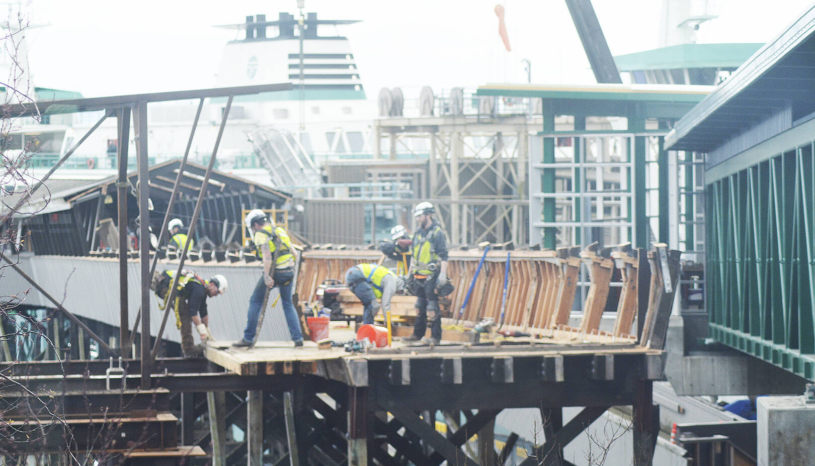 Steve Powell/Kitsap News Group Photos
A big group of workers is tearing down the old ferry passenger overpass on Bainbridge Island as the new one at right is now operational.