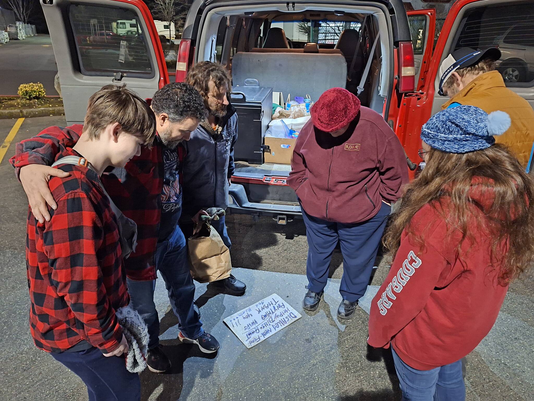 Elisha Meyer/Kitsap News Group photos
The Mercy Mobile volunteers huddle together with a couple homeless people for a moment of prayer.