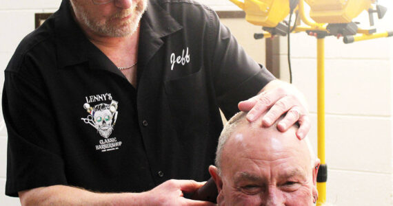 Elisha Meyer/Kitsap News Group
Jeff Crenshaw steadies the head of a customer while putting the finishing touches on a haircut.