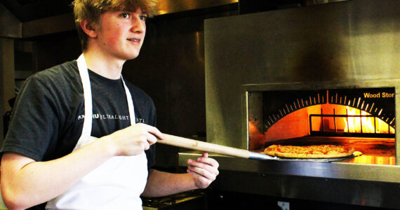 Madison Stevens courtesy photo
Student Grady Smallbeck takes a pizza out of the oven at The Odin Inn.
