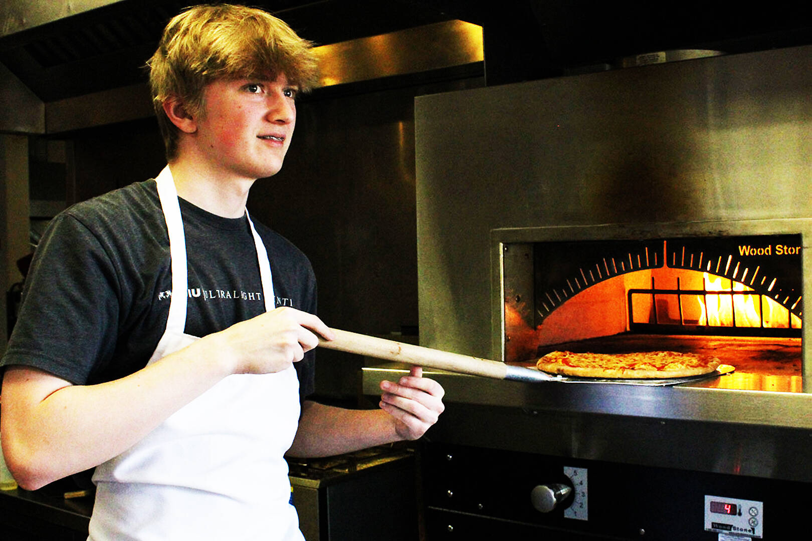Madison Stevens courtesy photo
Student Grady Smallbeck takes a pizza out of the oven at The Odin Inn.