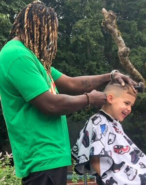 Chastity Malatesta courtesy photos
Donald “Swa” Francois gives Teo Malatesta a fade at an outdoor barbershop.