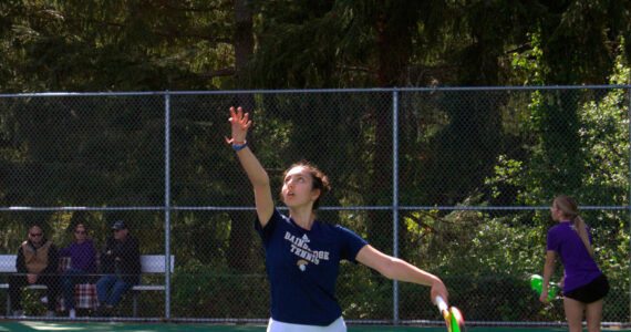 Luke Caputo/Kitsap News Group photos
Spartan Marta Llorens tosses the ball up for a serve in a 6-1, 6-2 doubles match win over North Kitsap April 30 at Bainbridge High School.