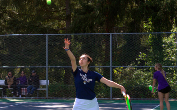 Luke Caputo/Kitsap News Group photos
Spartan Marta Llorens tosses the ball up for a serve in a 6-1, 6-2 doubles match win over North Kitsap April 30 at Bainbridge High School.