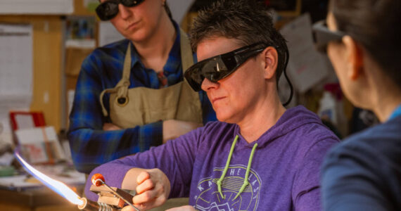 BARN Glass Arts instructor Laura Arns demonstrates torchworking techniques during a workshop. Courtesy BARN