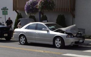 A sedan awaits a tow following a collision on Front Street.