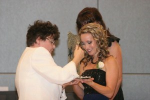 Past President Angela Sell gives April Ihde her award.