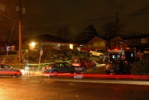 The tail lights of a passing car leave streaks in this long exposure image at the intersection of Lebo Boulevard and Oak Street in East Bremerton Nov. 7. Officers were investigating a likely homicide at the home at upper left.