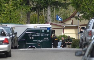 Officers stand near a 'Major crimes unit' van at Kariotis Mobile Home Park on March 28.
