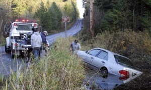 A Mercedes is hauled from a pond on Martha John Creek Thursday.