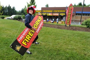 Stinger U11 baseball player Eric Halvorson looks to draw motorists from State Route 104 into his team’s stand at the Rite Aid parking lot in Kingston. The Stingers ball club of Bremerton is raising funds with a fireworks booth at the Kingston drug store this week.