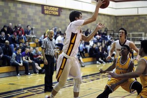 Spectators watch as a Kingston guard Brett Spencer passes to Kingston forward Gavin Veilleux (42) while Bremerton guard Phillip Grant (11) and a teammate attempt to block