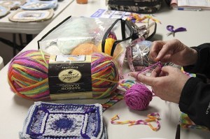 A member starts a new project during a monthly potluck meeting.