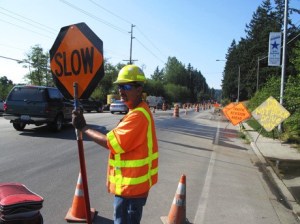 Flagger Robin Tinner waves cars through construction on south Viking Way. Up to 70 vehicles are queued at a time while one-way traffic alternates during the day