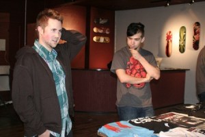 Graphic designers Greg Cook and Mark Gaviglio stand next to the T-shirts at Fingers Duke on Pacific Avenue in Bremerton. The design studio and screen printing shop aims to use young artists for their art shows and retail products.