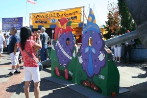 A woman who attended the Bremerton Blackberry Festival on Saturday photographs family members as they pose behind giant colorful blackberry cutouts. The annual festival brought hundreds of visitors to the waterfront and downtown.