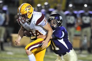 A Viking player knocks the ball out of Buccaneer running back Lou Hecker during the game Friday night. The game was the last of the regular season and the final Olympic League match-up.