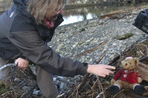Olympic College geography professor Susan Digby unearths a teddy bear on the Dyes Inlet shore near Old Mill Park in Silverdale.