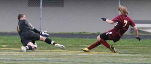 North Kitsap's Jordan Hadden jumps on to the soccer ball following a kick from Kingston's Justin Overton April 17 at North Kitsap High School Stadium. Hadden had the shutout at the goal