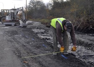 A construction worker marks a gravel fill line during final preparations at a temporary Kitsap Transit transfer station in Silverdale Tuesday