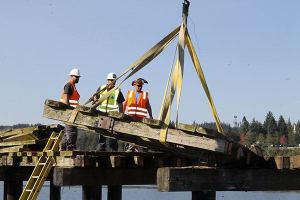 A forklift lifts a section of decking that was cut away from the Point Julia pier