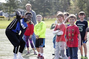 Kitsap Pumas defender Kalem Scott jokes with students from Poulsbo Elementary School during a soccer workshop at Strawberry Field on April 13.