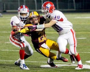 Kingston's Mikole Hendricks fights two Washington Patriots offensive linemen for the football during the Nov. 2 playoff game at North Kitsap Stadium. Kingston won 40-37 for a berth into the 2A State tournament.
