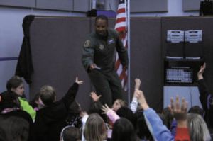 Senior Master Sgt. Derek Bryant tosses goodies to children who participated by answering or asking questions during Silverwood School’s Veterans Day assembly.