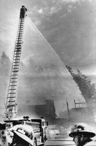 A firefighter sprays water on the smoldering Kingston shopping center on the morning of June 30