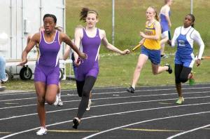 North Kitsap's Indigo Williams reaches back for a baton during the 4x100 Relay on May 7 during the Olympic League Championships.