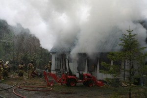 Central Kitsap Fire and Rescue firefighters battle a house fire near Seabeck Highway Monday afternoon.