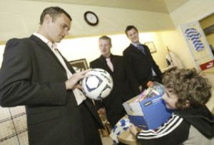 Kitsap Pumas midfielder Tony Kerr talks to young soccer fan Clayton Cole after a press conference April 23 at club headquarters in Bremerton. Kerr is among the Pumas players who will coach youth soccer camps this summer.