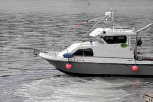 A boat leaves the Kingston docks to help bring in the capsized boat.