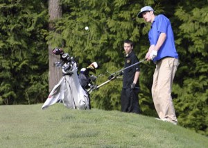 Chimacum High School’s Mason Mong chips a ball onto the green on the eighth hole at White Horse Golf Club on April 18. The challenging course has undergone improvements to make it friendlier.