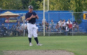 Kitsap BlueJackets coach Matt Acker uses a hand signal during the team’s 9-8 win Tuesday over the Kelowna Falcons at Gene Lobe Field at the Kitsap County Fairgrounds.
